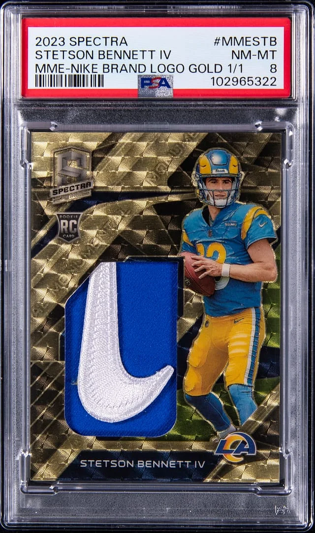 2023 Panini Spectra Stetson Bennett IV Monumental Memorabilia Nike Brand Logo Gold #MEE-STB card image