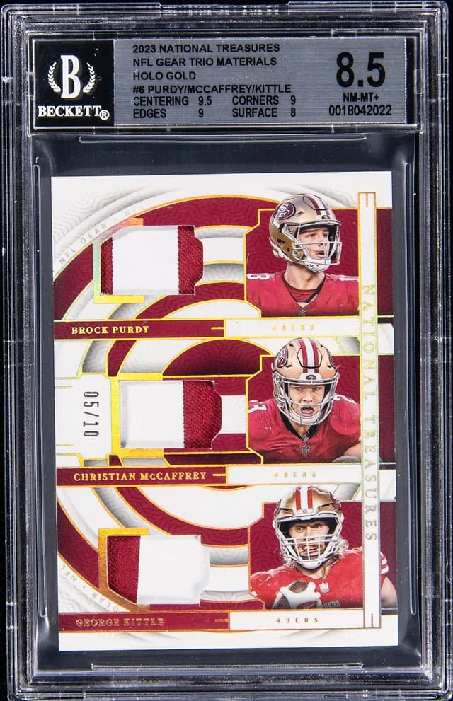 2024 Panini National Treasures Brock Purdy, Christian McCaffrey, George Kittle NFL Gear Trio Materials-Holo Gold #6 card image
